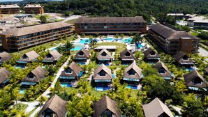 A resort with multiple bungalow-style accommodations, a central swimming pool, and lush greenery.