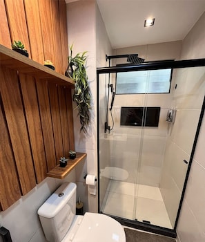 A modern bathroom with a glass shower enclosure, wooden vanity, and a small shelf with plants. - Eco Resort - Praia dos Carneiros (Rio Formoso)