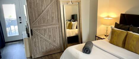 Relax in a spacious room with a large bed, balcony access, and a cozy reading area.