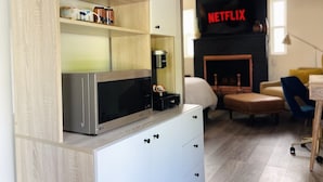 Eine moderne Küche mit einer LG-Mikrowelle, einer Kaffeemaschine und einem Regal mit Küchenutensilien.