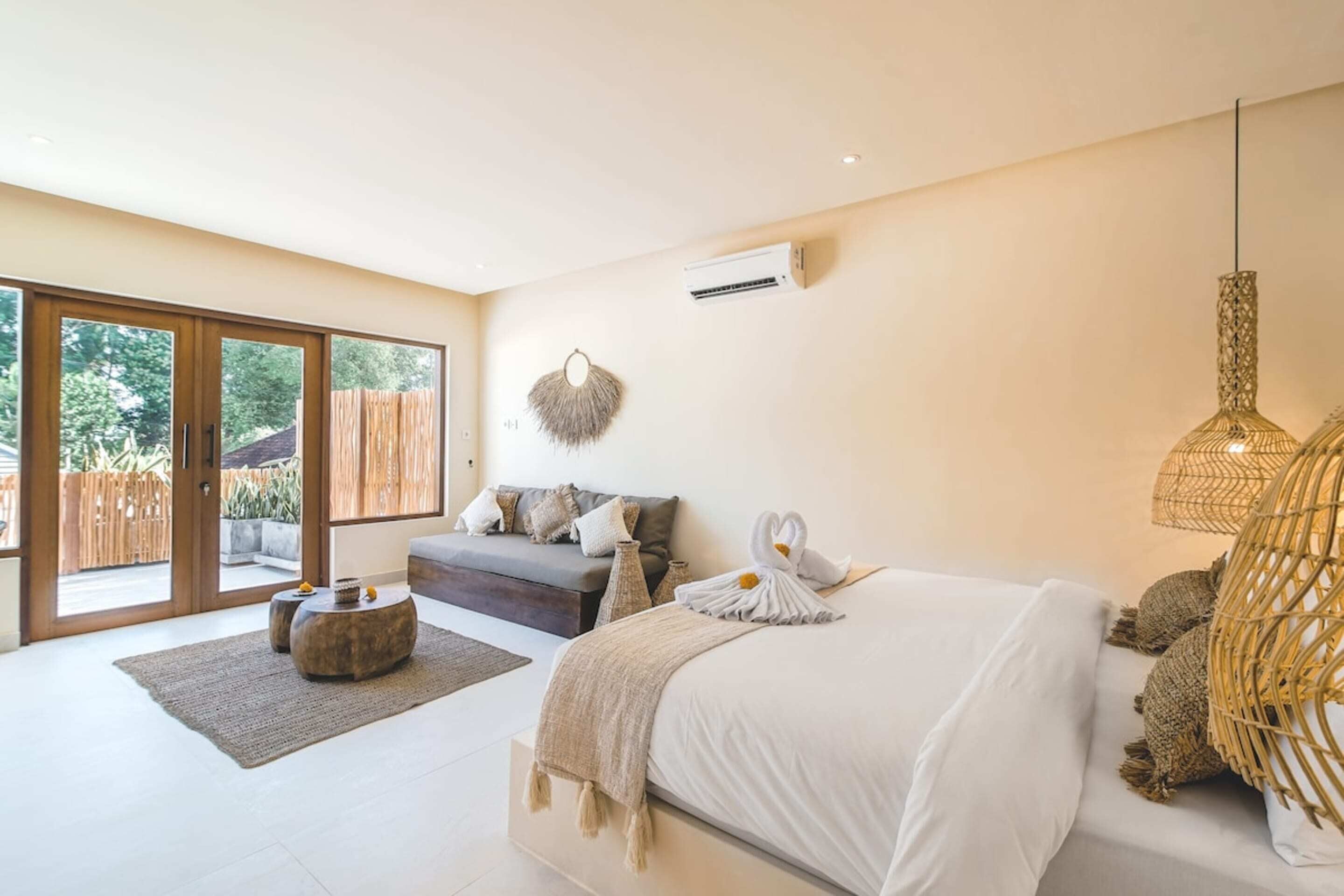 A spacious bedroom with a large bed, a sofa, and a dining area.