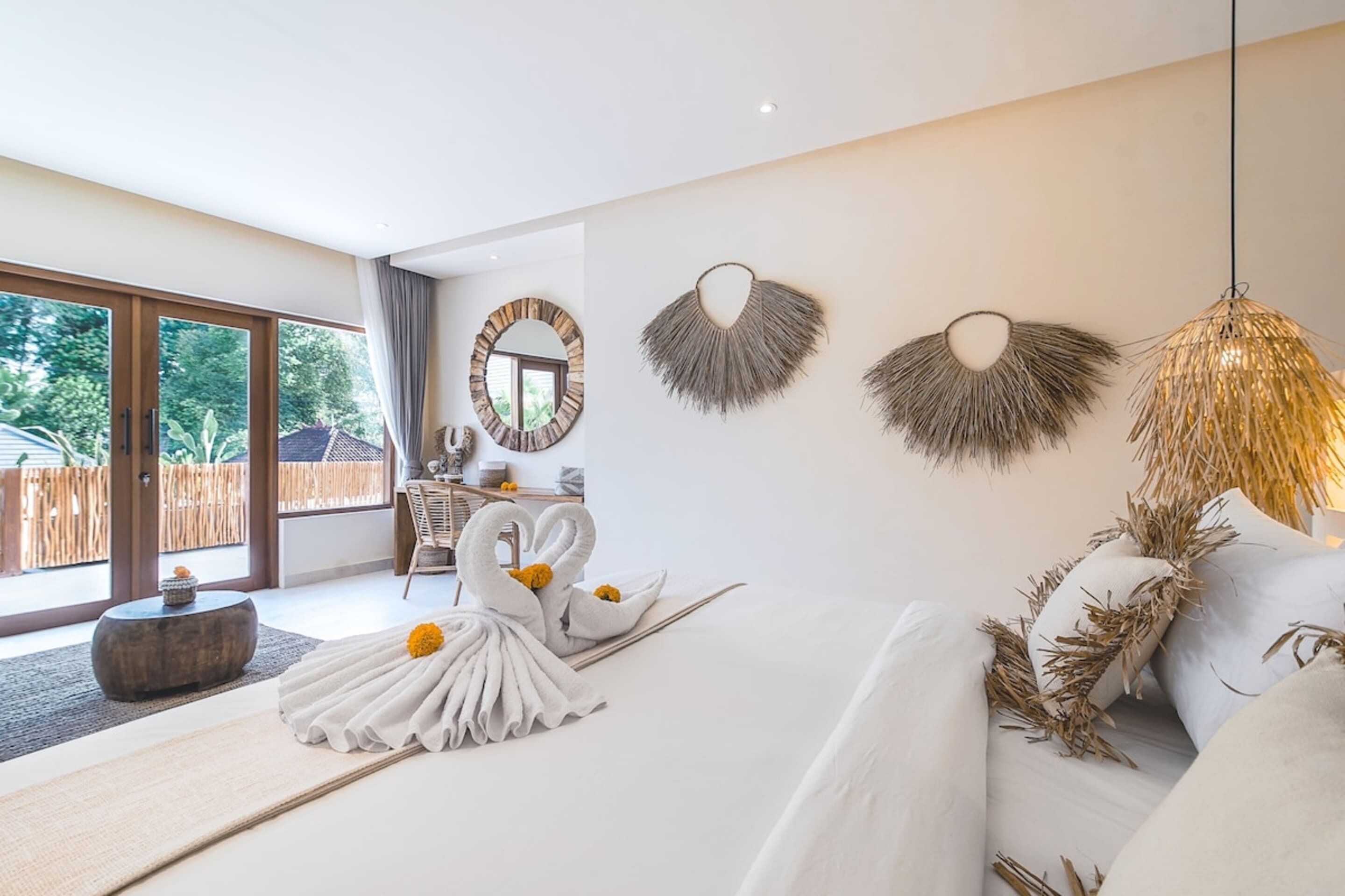 Habitación de hotel moderna con una cama grande, un área de comedor y vistas al exterior.