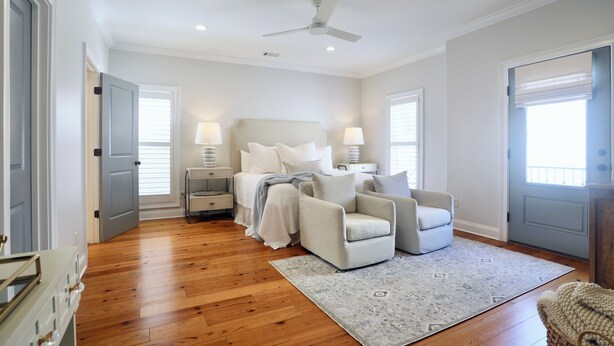 A bedroom with a bed, two bedside tables, a chair, a rug, and a ceiling fan. - Charming Oxford Townhome - Minutes to Ole Miss and The Square!  Sleeps 1-10 (Oxford)
