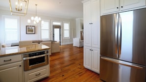 A modern kitchen with white cabinetry, a stainless steel refrigerator, and a built-in oven. - Charming Oxford Townhome - Minutes to Ole Miss and The Square!  Sleeps 1-10 (Oxford)