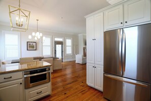 Una cucina moderna con mobili bianchi, un frigorifero in acciaio inossidabile e un forno integrato.