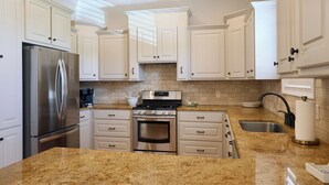 A modern kitchen with white cabinets, stainless steel appliances, granite countertops, and a built-in oven. - Charming Oxford Townhome - Minutes to Ole Miss and The Square!  Sleeps 1-10 (Oxford)