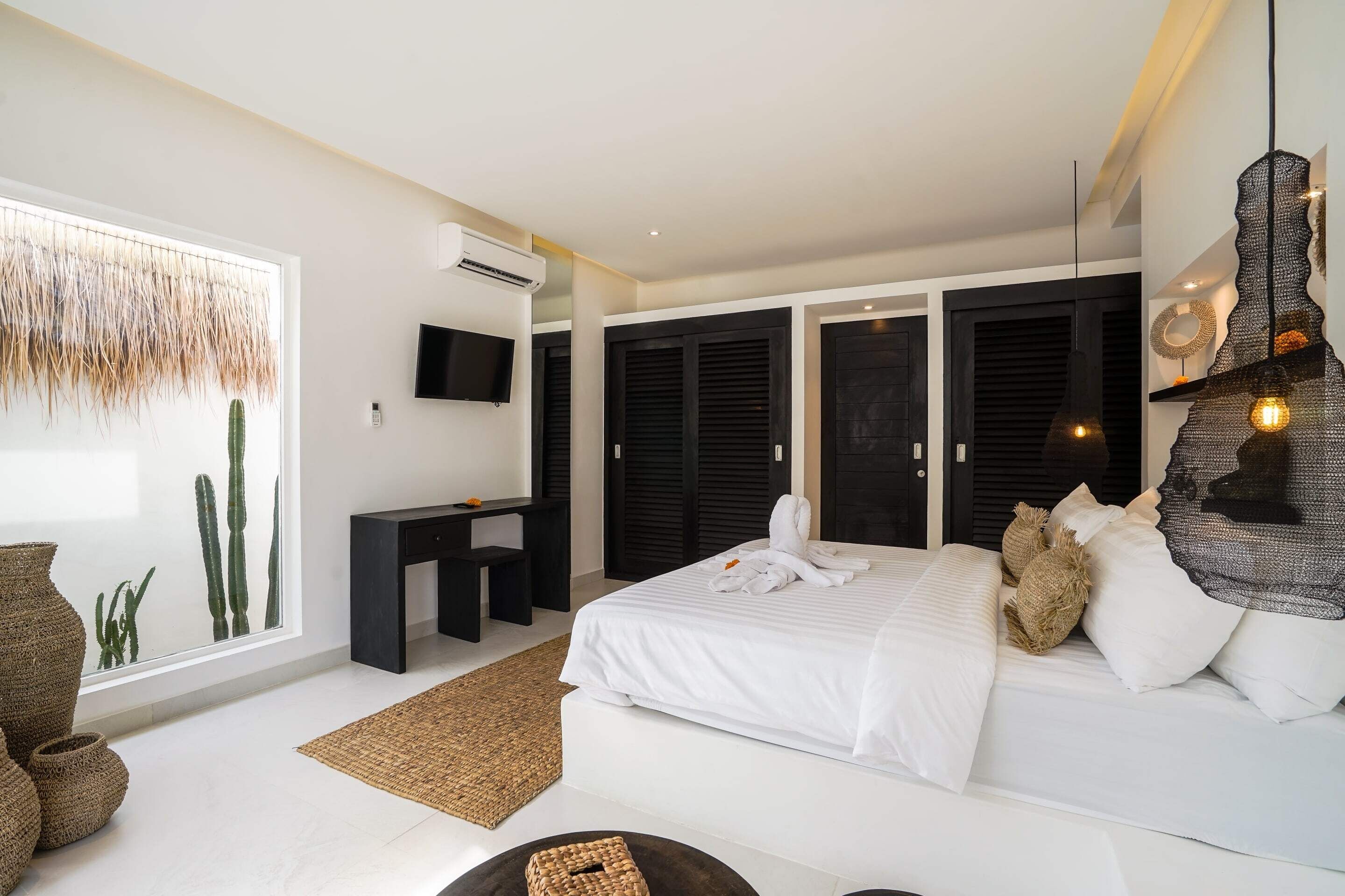 Una camera da letto moderna con un letto grande, una scrivania e una TV.