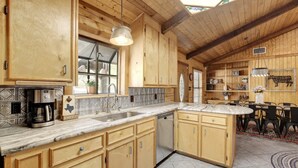 Una cocina de madera con una isla grande, una cafetera y un lavabo.