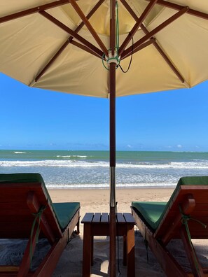 On the beach, white sand, sun loungers, beach umbrellas