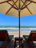 En la playa, arena blanca, sillas reclinables de playa, sombrillas