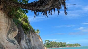 On the beach, white sand, sun-loungers, beach umbrellas