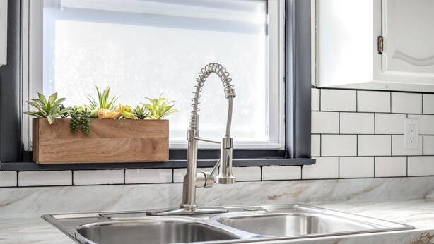 A kitchen with a double sink, a wooden planter with plants, and a window above the sink. - Modern Zen Farmhouse to help you recharge and rejuvenated (Royal Oak)