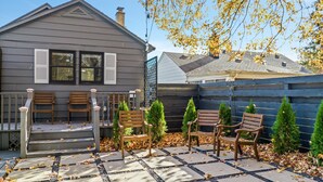 A house with a porch, wooden benches, and a fenced yard with evergreen trees. - Modern Zen Farmhouse to help you recharge and rejuvenated (Royal Oak)