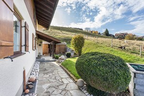 A house with a stone pathway, a wooden door, and a well-maintained lawn.