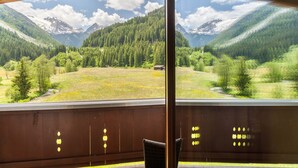 A room with a large window overlooking a mountainous landscape.