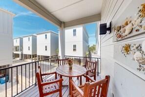 Enjoy a seaside view from this balcony with a table for four and a flat-screen TV.