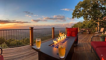 A deck with a fire feature, outdoor seating, and a view of the landscape.
