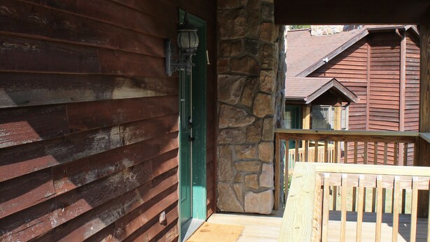 A wooden exterior of a building with a stone wall and a wooden deck. - Stones Throw from Giant City Park, Wineries, Hiking, Biking, Hunting and more. (Makanda)