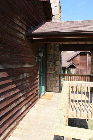 Un bâtiment avec une façade en bois, un mur en pierre et une terrasse en bois.