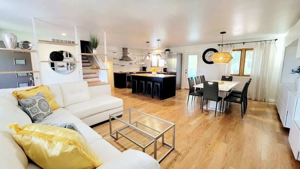 A modern living room with a sofa, a coffee table, and a dining area with chairs and a table. - $0 Fees-Hot Tub, Lake View Oasis-Near Shops/Dining (Arvada)