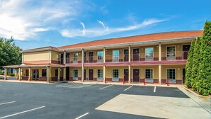Un motel composé d’un bâtiment à deux étages, d’un espace de stationnement couvert et d’une façade bien entretenue.