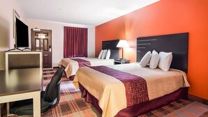 Une chambre d’hôtel avec deux lits, un bureau, une télévision et une lampe.