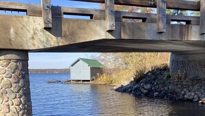 Kivinen silta ylittää tyynen joen, ja sen päällä on puinen kävelyreitti.