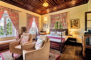 A room with a bed, two armchairs, a wooden ceiling, and a painting on the wall. - Sterling Park Kalimpong (Kalimpong)