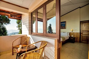 A balcony with wicker furniture and a view of the mountains. - Sterling Park Kalimpong (Kalimpong)