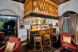 A bar area with a wooden counter, bar stools, and a view of the outdoors. - Sterling Park Kalimpong (Kalimpong)