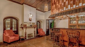 A bar area with wooden furniture, a fireplace, and a display of bottles. - Sterling Park Kalimpong (Kalimpong)