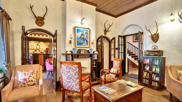 A traditional interior with wooden furniture, a fireplace, and antler decorations.