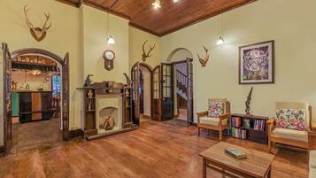 Un salon spacieux doté d’un parquet, d’une cheminée et d’une bibliothèque.