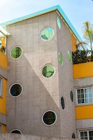 Un edificio con varias ventanas circulares y fachada amarilla.