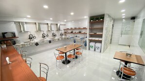 A modern kitchen with a central island, stainless steel appliances, and a dining area with bar stools. - La Casa del Reloj - Zona de Hospitales (Mexico City)