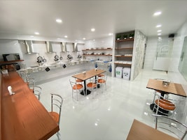 Una cocina moderna con una isla central, electrodomésticos de acero inoxidable y una zona de comedor con taburetes de bar.