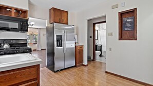 Una cocina moderna con electrodomésticos de acero inoxidable, armarios de madera y un dispensador de agua integrado.
