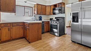 Una cocina moderna con armarios de madera, electrodomésticos de acero inoxidable y horno integrado.