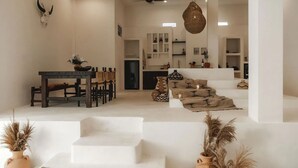 A spacious living area with a dining table, sofas, and a staircase leading to another level. - Villa Ores Bali (Canggu)