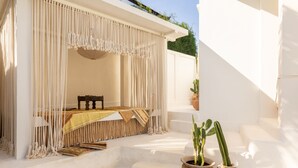 A white-walled room with a bed, a small table, and two potted cacti. - Villa Ores Bali (Canggu)