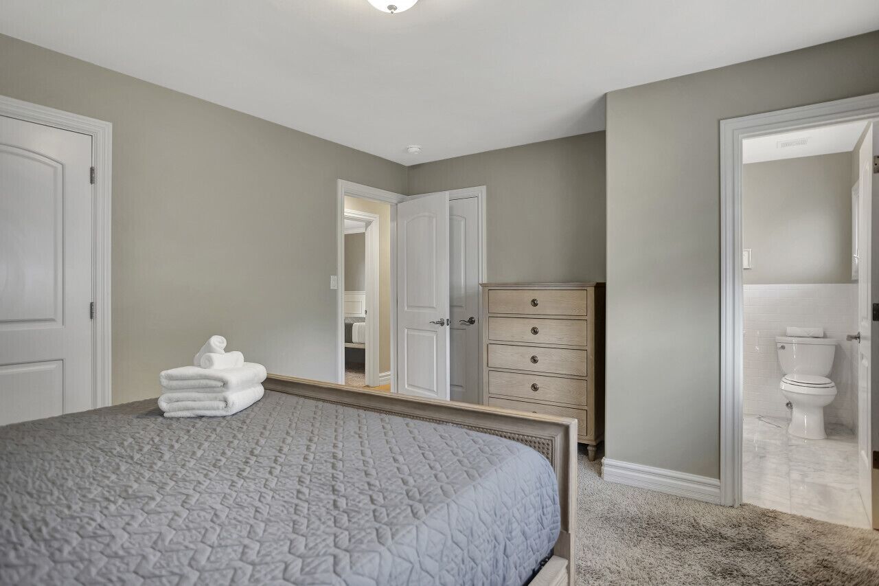 Ein Schlafzimmer mit einem großen Bett, einem Schminktisch und einem begehbaren Kleiderschrank.