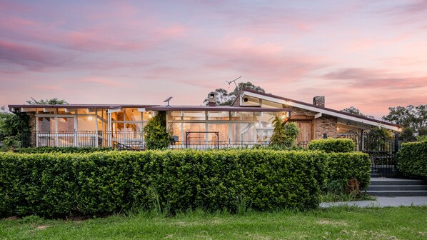 A modern house with large windows, a covered patio, and a well-maintained garden. - Mars: The Menangle Hideaway: Relax and Unwin (Menangle)