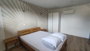 Une chambre à coucher avec un lit en bois, une table de chevet, une armoire et un ventilateur de plafond.