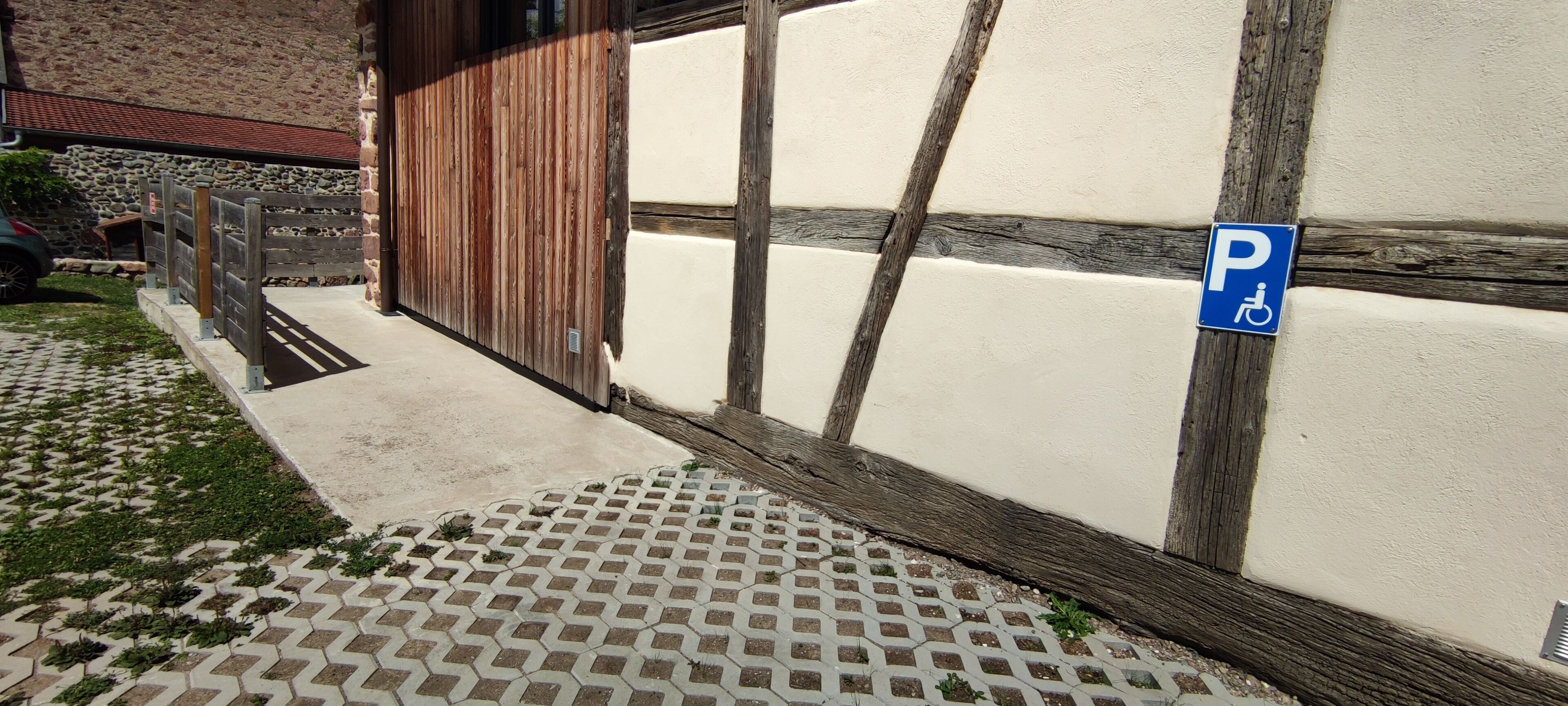 A building with a wooden facade and a parking sign indicating disabled parking.