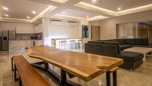 A modern kitchen with a marble countertop, a wooden dining table, and a built-in bench. - 7 Bedroom in Clock Tower Plaza with Private Pool (Cartagena)