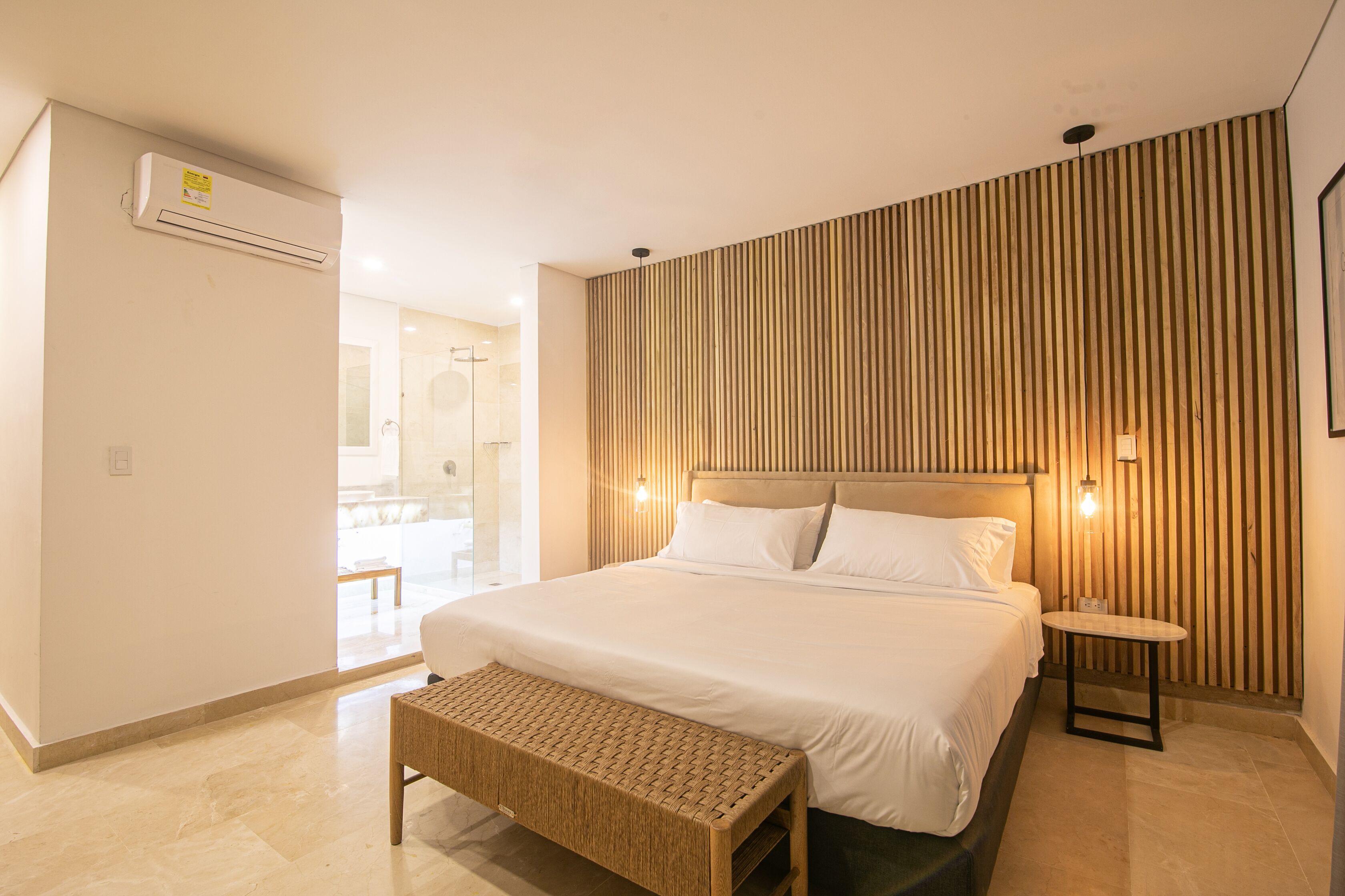 Una habitación de hotel moderna con una cama grande, un revestimiento de madera en la pared y una pequeña mesa.