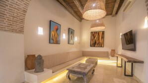 Una sala de estar moderna con un sofá, una mesa de centro y obras de arte en las paredes.