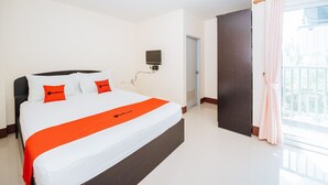 A hotel room with a large bed, a flat-screen TV mounted on the wall, and a balcony with curtains. - Supatranai Home Cha-am (Cha-am)