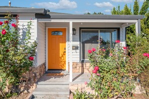 A house with a yellow door, stone steps, and a number 139 on the wall.