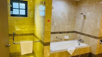 A bathroom with a glass shower enclosure, a bathtub, and a vanity with a mirror.